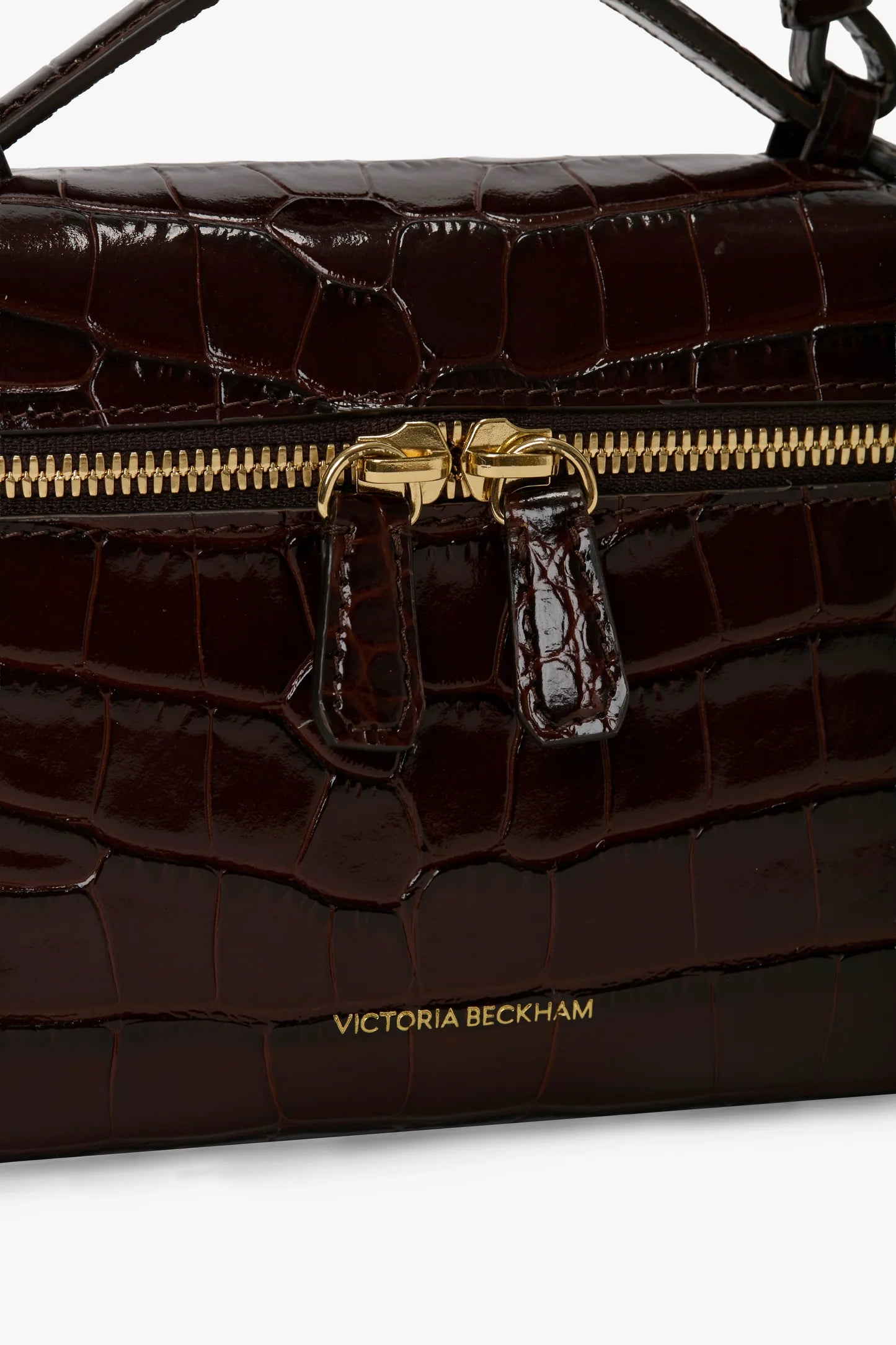 Close-up of the Victoria Beckham Vanity Croc Crossbody, featuring dark brown croc-embossed leather, gold zipper, organized compartments, and a gold "Victoria Beckham" logo.