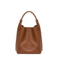 The Victoria Bucket by Victoria Beckham features a modern look in dark tan nappa leather, with a single handle, visible seam details, and the brand’s logo on the lower front.