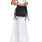 Person wearing a white dress with side buttons and black boots, carrying the Proenza Schouler Drawstring Nylon Tote.