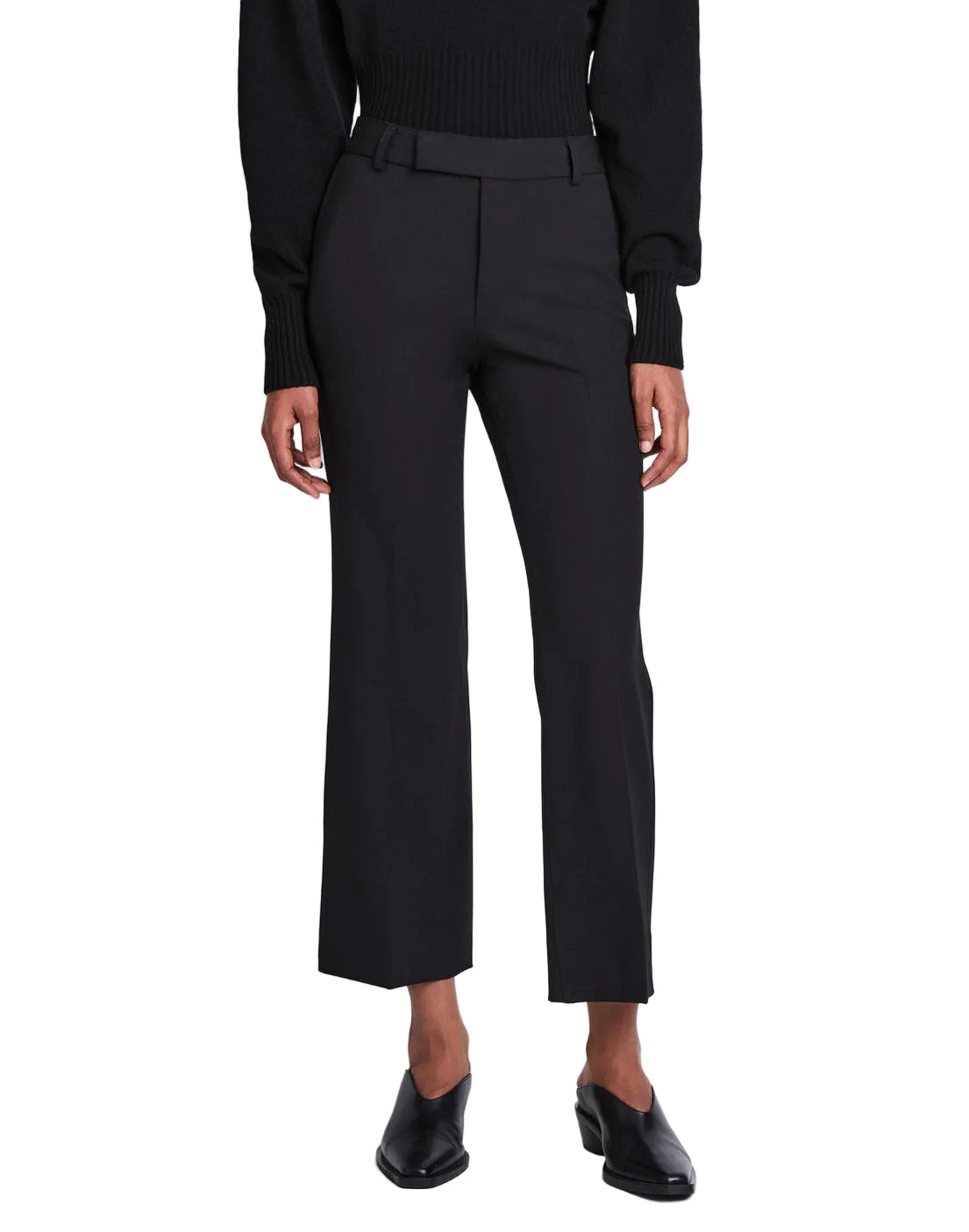 A person is wearing the Proenza Schouler Marlene Tropical Wool Pant in black, featuring a high-rise and cropped length, styled with a black top and black heeled shoes, standing facing forward against a plain white background.