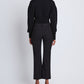 A person stands facing away against a plain white background, wearing a black long-sleeve top, black shoes, and the Proenza Schouler Marlene Tropical Wool Pant—high-rise, tailored, and cropped.
