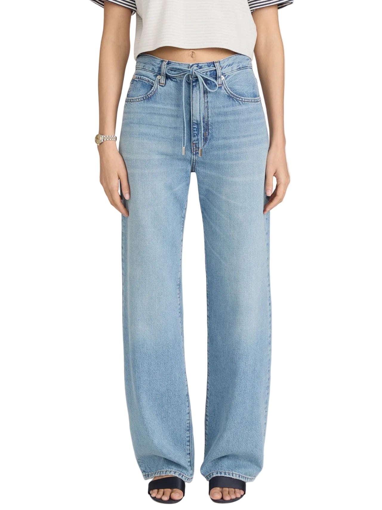 Person wearing The Off Duty Drawstring Bow high-waisted wide-leg jeans by Frame, styled with a cropped short-sleeve top and black open-toe shoes. The high-rise waist flatters the look; face not shown.