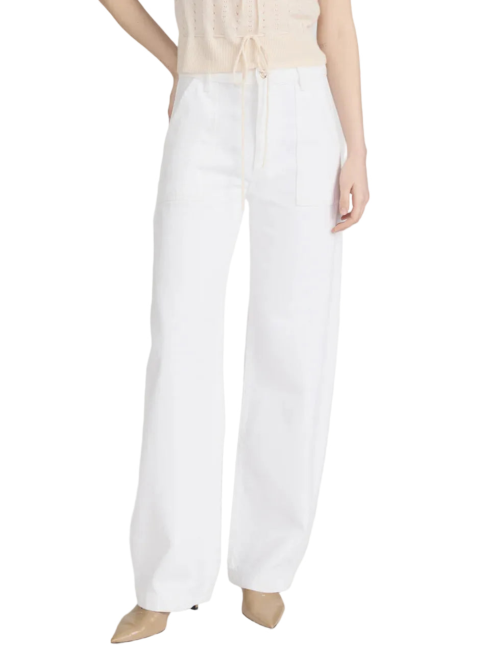 A person wearing Frame's The Bow Cargo high-waisted, wide-leg white pants with a utilitarian vibe, a sleeveless beige top, and beige pointed-toe shoes.