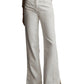 Someone in the TWP Tangled Up In Blue Pant, featuring a high-waisted, wide-leg design with five pockets, pairs them with black shoes against a neutral background.