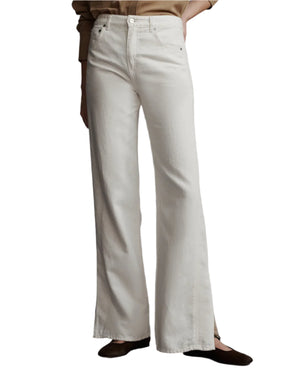 Someone in the TWP Tangled Up In Blue Pant, featuring a high-waisted, wide-leg design with five pockets, pairs them with black shoes against a neutral background.