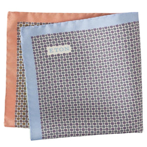 The Eton Four-Sided Silk Pocket Square showcases classic elegance with a small circular pattern and light blue-peach borders, expertly crafted from fine silk yarn.
