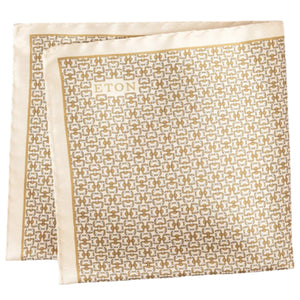 The Eton Geometric Silk Pocket Square features a folded cream and gold geometric print with "ETON" in the corner, made in Italy.