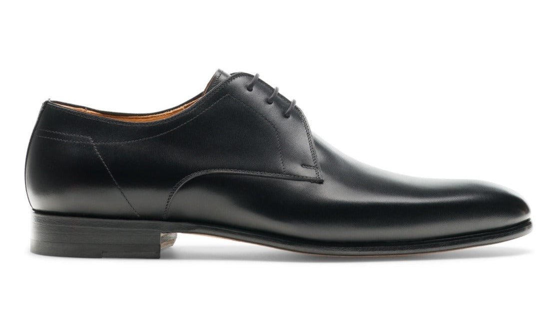 The Magnanni Maddin Lace-Up, a black leather dress shoe from the renowned brand Magnanni, is crafted from fine calfskin and features the classic Derby style with laces and a low heel. This Línea Flex design showcases a smooth finish, presenting an elegant side profile.