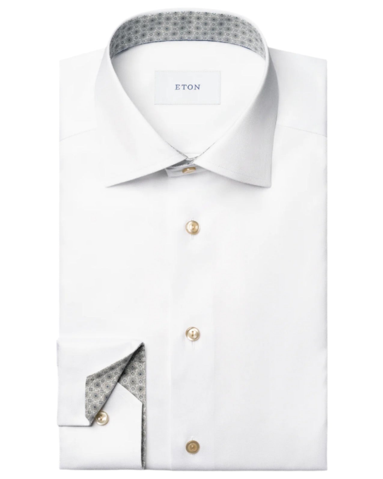 A folded Eton Slim Cut Away Medallion Effect Signature Twill Shirt in white features beige buttons, a patterned inner collar and cuff, and the "Eton" label inside the collar.