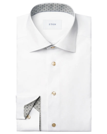 A folded Eton Slim Cut Away Medallion Effect Signature Twill Shirt in white features beige buttons, a patterned inner collar and cuff, and the "Eton" label inside the collar.