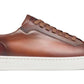 Side view of a Magnanni Amadeo Sneaker, a brown leather fashion sneaker with a white rubber cupsole and brown laces, exemplifying contemporary luxury.