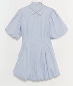 The Cleo Dress by Simkhai is a light blue cotton mini dress featuring a collar, button-down front, pintuck details at the pleated waist, and slightly puffed sleeves, shown against a plain white background.