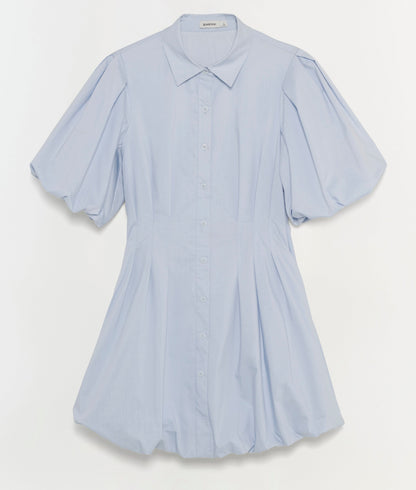 The Cleo Dress by Simkhai is a light blue cotton mini dress featuring a collar, button-down front, pintuck details at the pleated waist, and slightly puffed sleeves, shown against a plain white background.