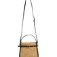 The Simkhai Cleo Mini Raffia Bucket Bag features black leather trim, gold-tone hardware, a top handle, and an adjustable shoulder strap.