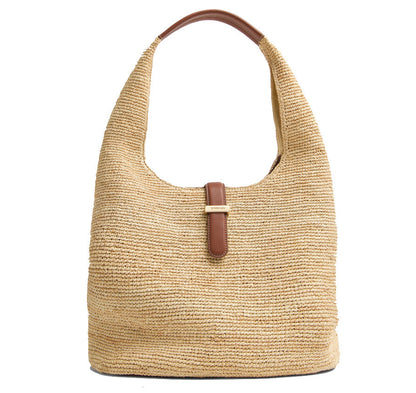 The Simkhai Khai Large Raffia Hobo Bag features beige woven raffia, a single brown leather strap, and a center leather buckle closure.