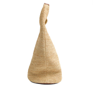 Side view of the Simkhai Khai Large Raffia Hobo Bag with a rounded base, single handle, and subtle leather buckle, shown against a white background.