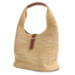 The Simkhai Khai Large Raffia Hobo Bag is a tan woven bag with a wide handle, accented by a brown leather buckle and strap on the front for an effortlessly chic touch.