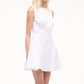 A woman stands against a plain light background wearing the Staud Gwen Mini Dress, a sleeveless white poplin A-line dress with structured pleats.