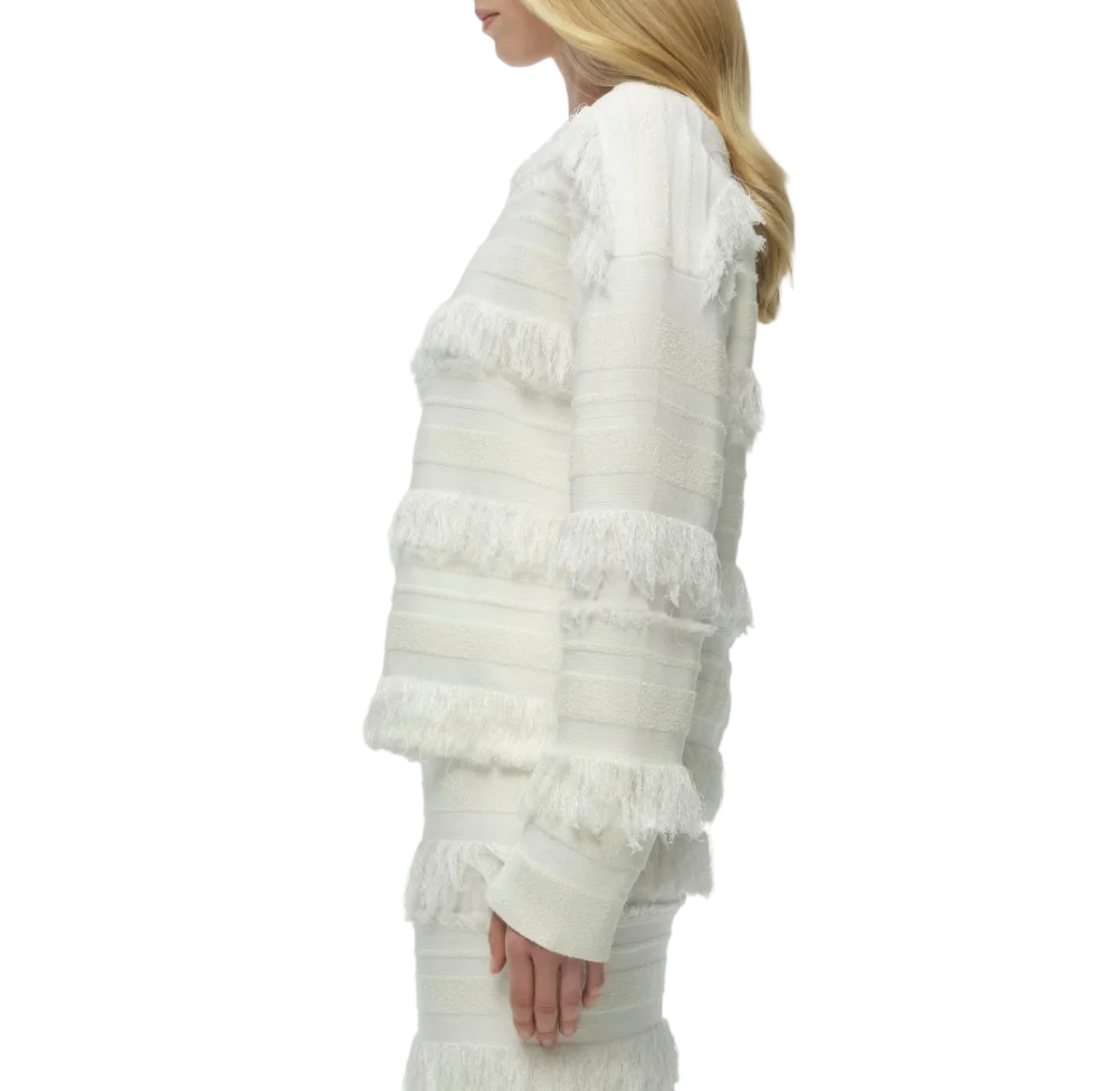 A woman stands in profile against a plain white background, wearing the Simkhai Carrick Crewneck Sweater—a white knit long-sleeve top with subtle horizontal striping—paired with a matching skirt.