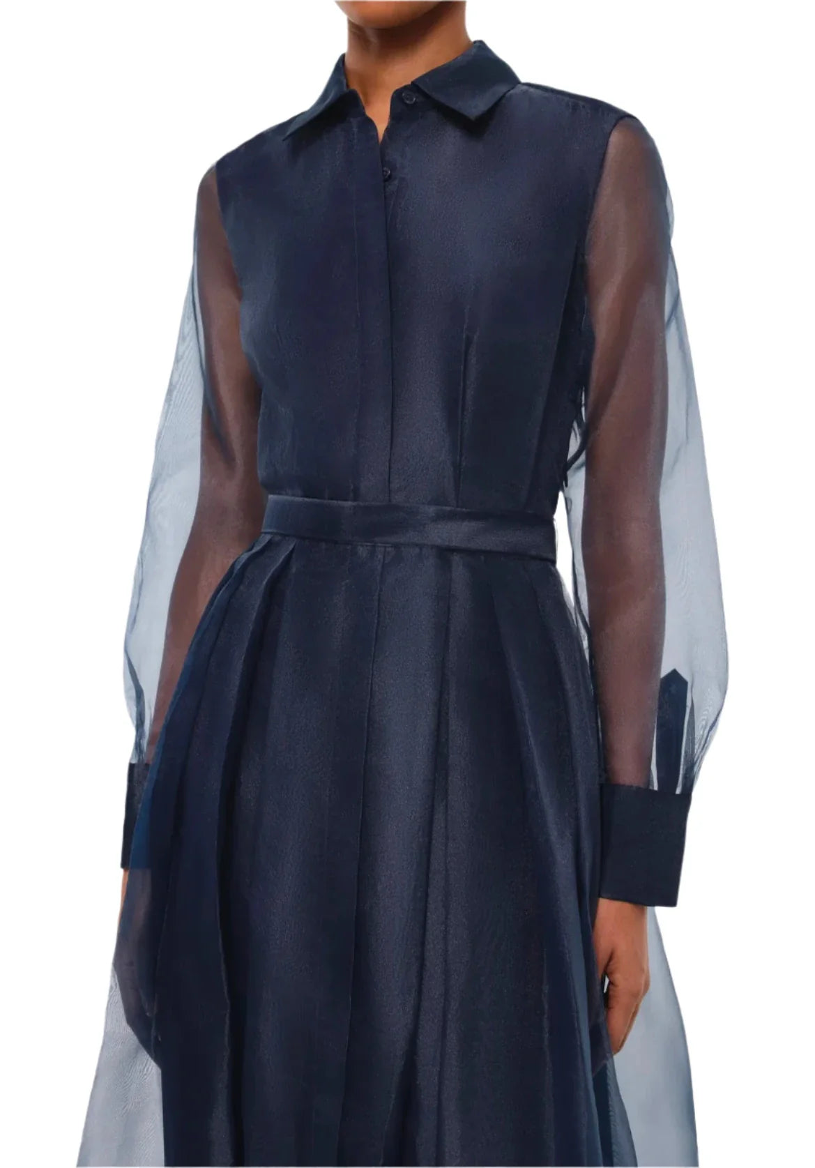 The individual is dressed in the Simkhai Montgomery Dress, a dark blue, long-sleeve piece featuring a sheer overlay and an elegant midi-length design.