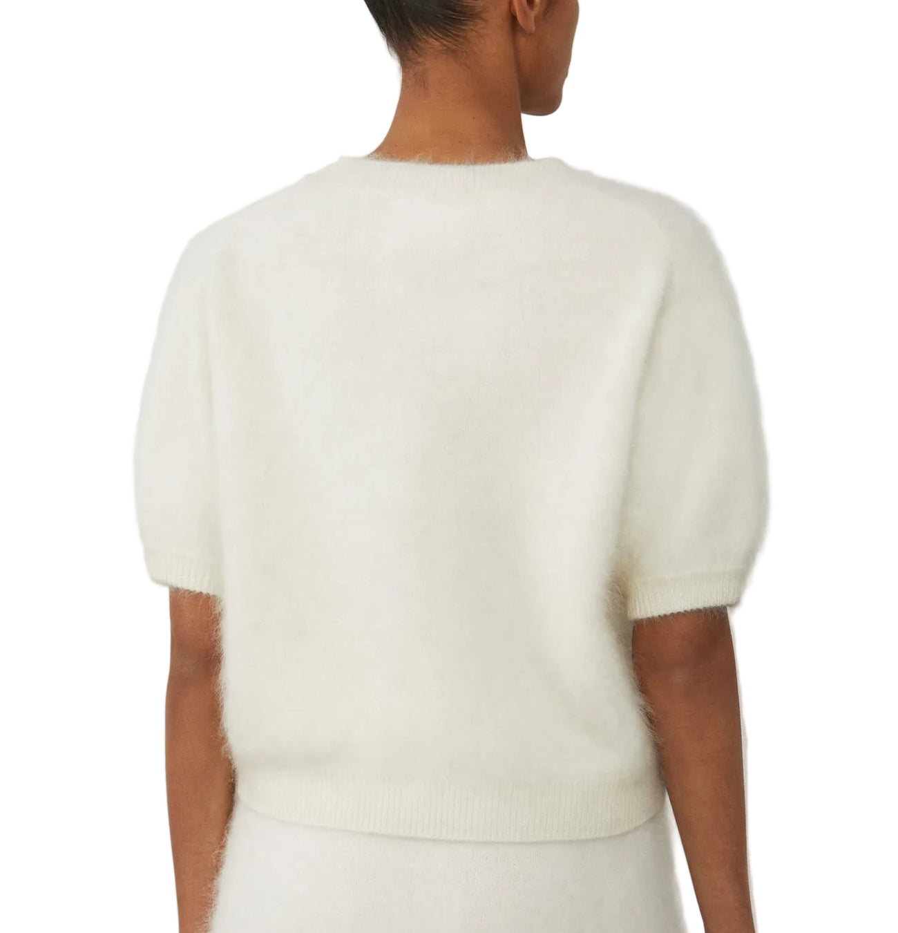 A person is shown from the back wearing the Lisa Yang Juniper Brushed Cashmere Sweater, a white, short-sleeve cropped style made from a soft, fuzzy knit.