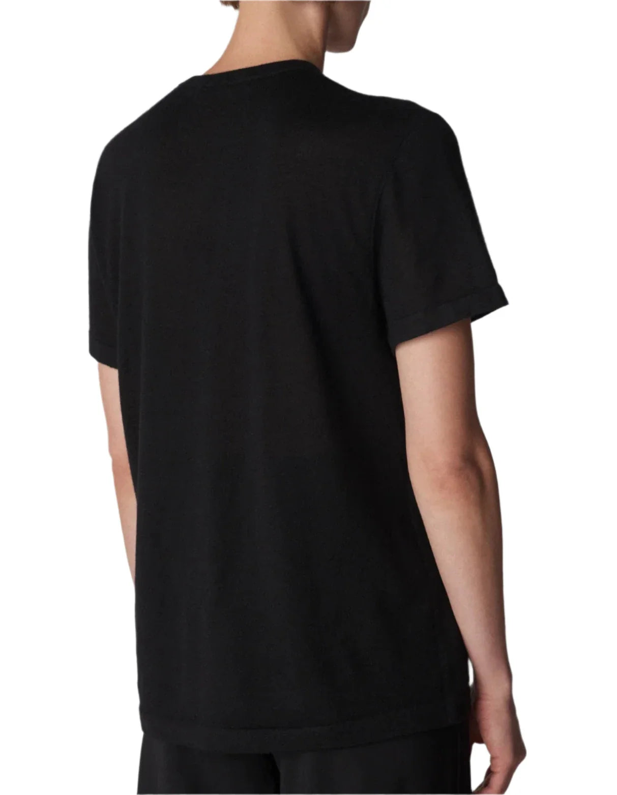 A person with short hair is wearing a plain black, lightweight CO Cashmere Tee by CO with short sleeves, standing with their back to the camera.