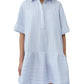 A woman wears the Simkhai Cris Short Sleeve Shirt Dress featuring blue stripes, a collared neckline, loose fit, and ruffled hem.