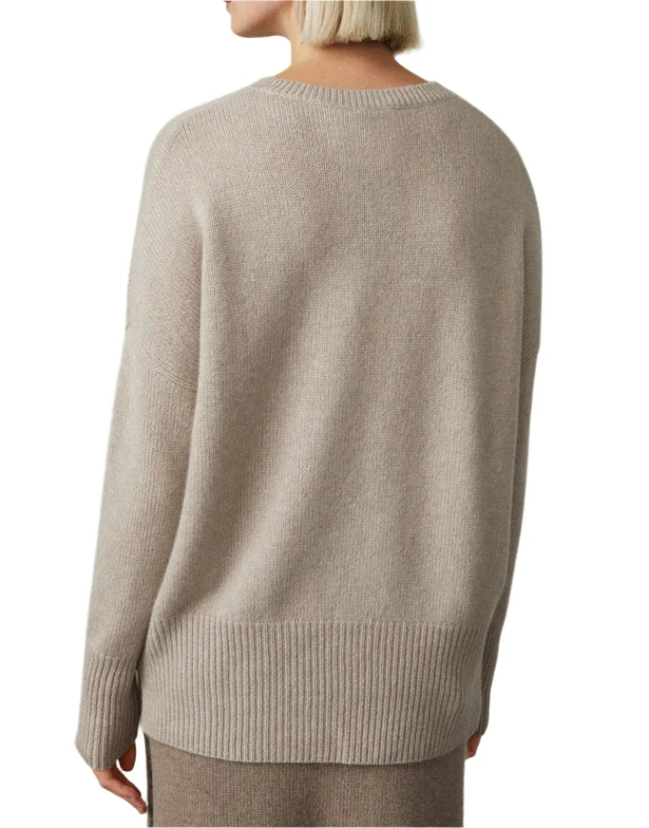 A person with short blonde hair is wearing the Lisa Yang Mila Cashmere Sweater in beige, viewed from the back.