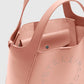 Close-up of the Stella McCartney Logo Crossbody Tote Bag in pink vegan leather, featuring a snap-button pouch inside and perforated logo branding on the exterior.