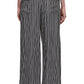 Back view of a person in Maria McManus's Flap Pocket Pleat Pant, featuring vintage-inspired black and white vertical stripes on silky cupro, paired with a sleek black top.