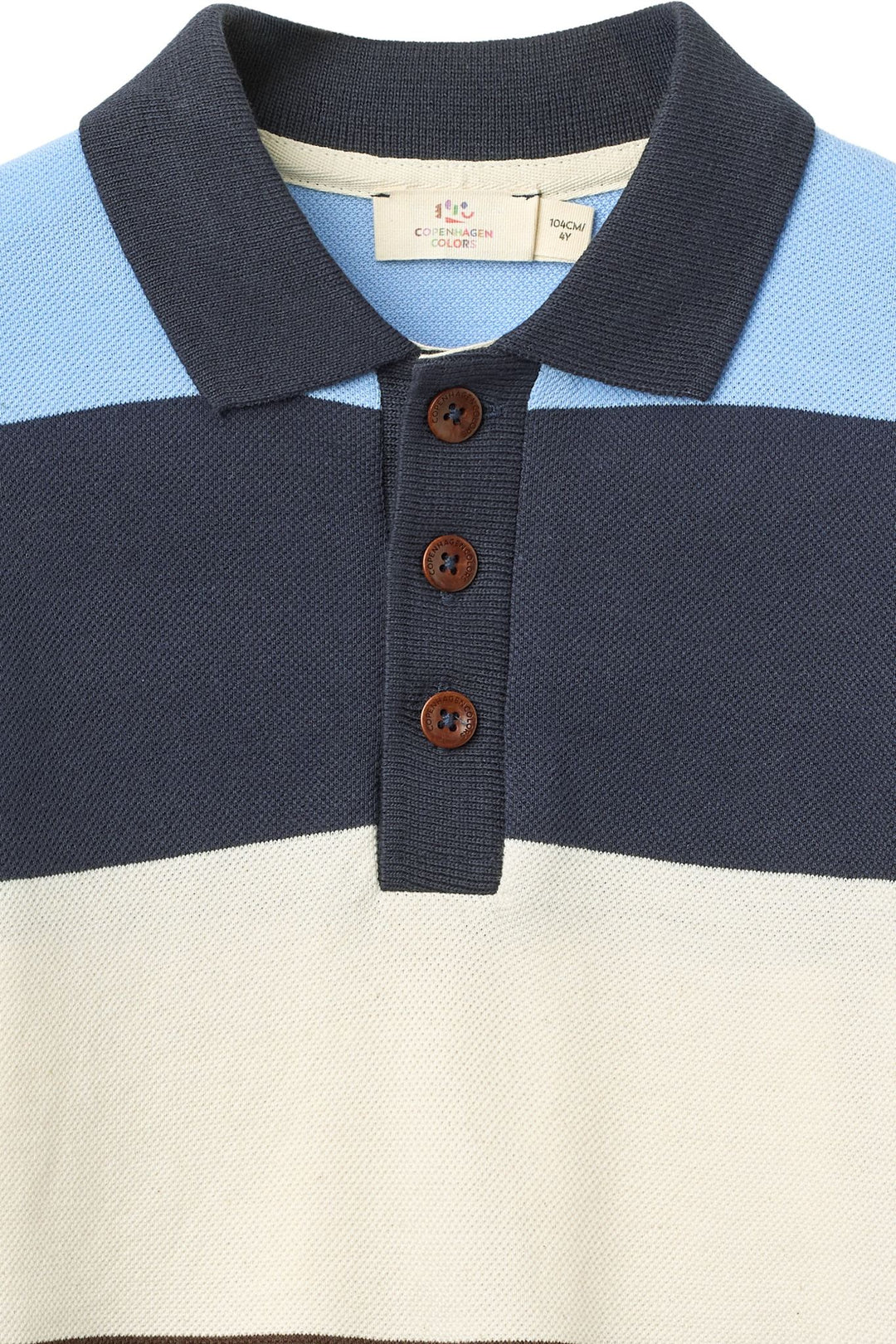A close-up of the Copenhagen Colors Baby Boys’ and Boys’ Striped Pique Long Sleeved Polo with blue, navy, and cream stripes and three brown buttons on the placket.