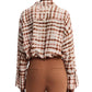 Rear view of a person wearing a Dorothee Schumacher Checked Statement Blouse featuring an oversized plaid design in shades of brown and white, paired with silk-infused brown pants.