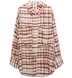 The Dorothee Schumacher Checked Statement Blouse combines an oversized plaid design in brown and white with long sleeves, a collar, and two chest pockets, all crafted from silk-infused fabric for a luxurious touch.