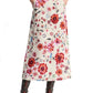 A person wearing the Dorothee Schumacher Floral Ease Skirt along with a matching blouse, accented by a leather tie belt and cowboy boots, stands casually with hands tucked into pockets.