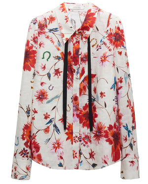 The Dorothee Schumacher Floral Ease Blouse, by Dorothee Schumacher, showcases Western-inspired styling with its long sleeves adorned with red and orange floral prints and black ribbon detailing near the collar.