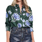 A person wearing the Dorothee Schumacher Big Garden Blouse, a relaxed fit green silk twill blouse with a blue and white floral print, paired with dark jeans.