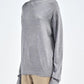 A person wearing the Maria McManus Fine Gauge Mock Neck Sweater in heather grey with beige pants, standing against a plain background.