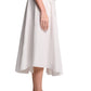 A person is shown from the side against a white background wearing a light-colored cardigan, olive green heeled sandals, and the Poplin Power Skirt by Dorothee Schumacher.