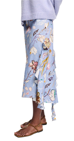 A person wearing the Dorothee Schumacher Floral Power Skirt with floral patterns, paired with a lavender sweater and brown sandals.