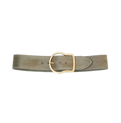 The Suede Sensation Belt by Dorothee Schumacher, a wide light olive green leather belt with a waxed finish and a rounded gold buckle, is displayed on a white background.