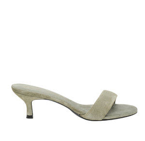 The Suede Sensation Kitten Heel by Dorothee Schumacher is showcased on a white background, featuring a light gray suede slide with an open toe and a contour kitten heel.