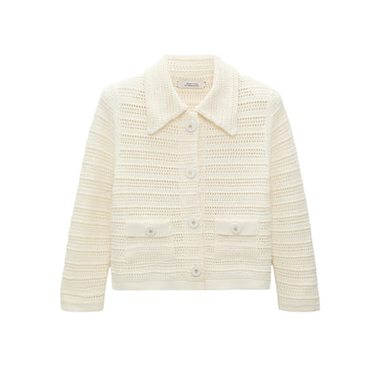 The Precise Pointelle Jacket by Dorothee Schumacher is cream-colored, long-sleeve, and cropped with a graphic pointelle design, collar, front buttons, and two front pockets, shown on a white background.