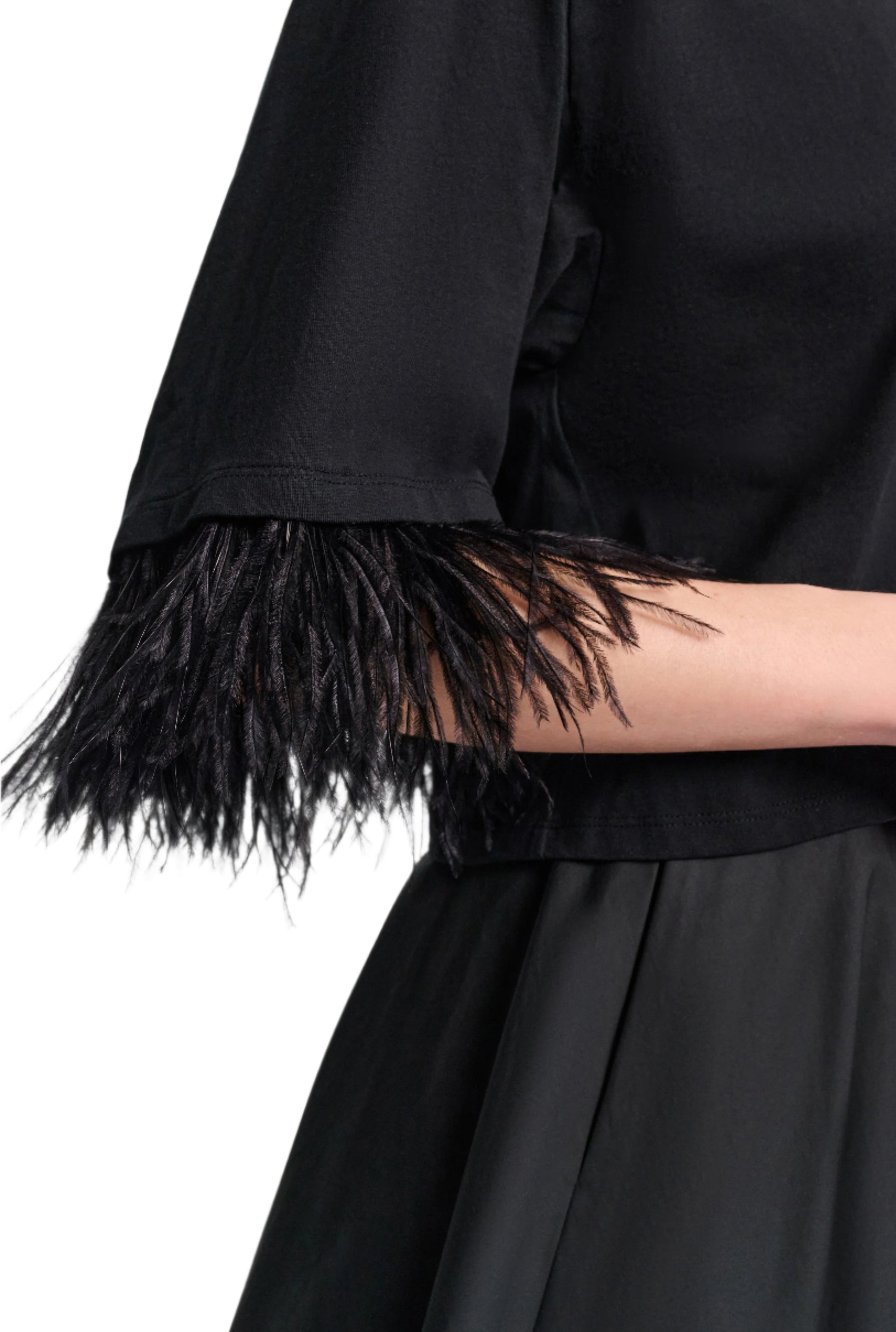Model wears the Dorothee Schumacher Feminine Favorites Shirt, a black boxy cotton tee with ostrich feather-trimmed sleeves, paired with a black skirt. Shown from shoulder to waist against a white background.