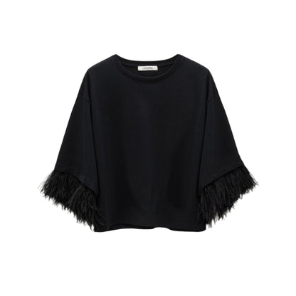 The Dorothee Schumacher Feminine Favorites Shirt is a black, short-sleeve boxy cotton tee with wide sleeves and black ostrich feather trim at the cuffs, shown against a white background.