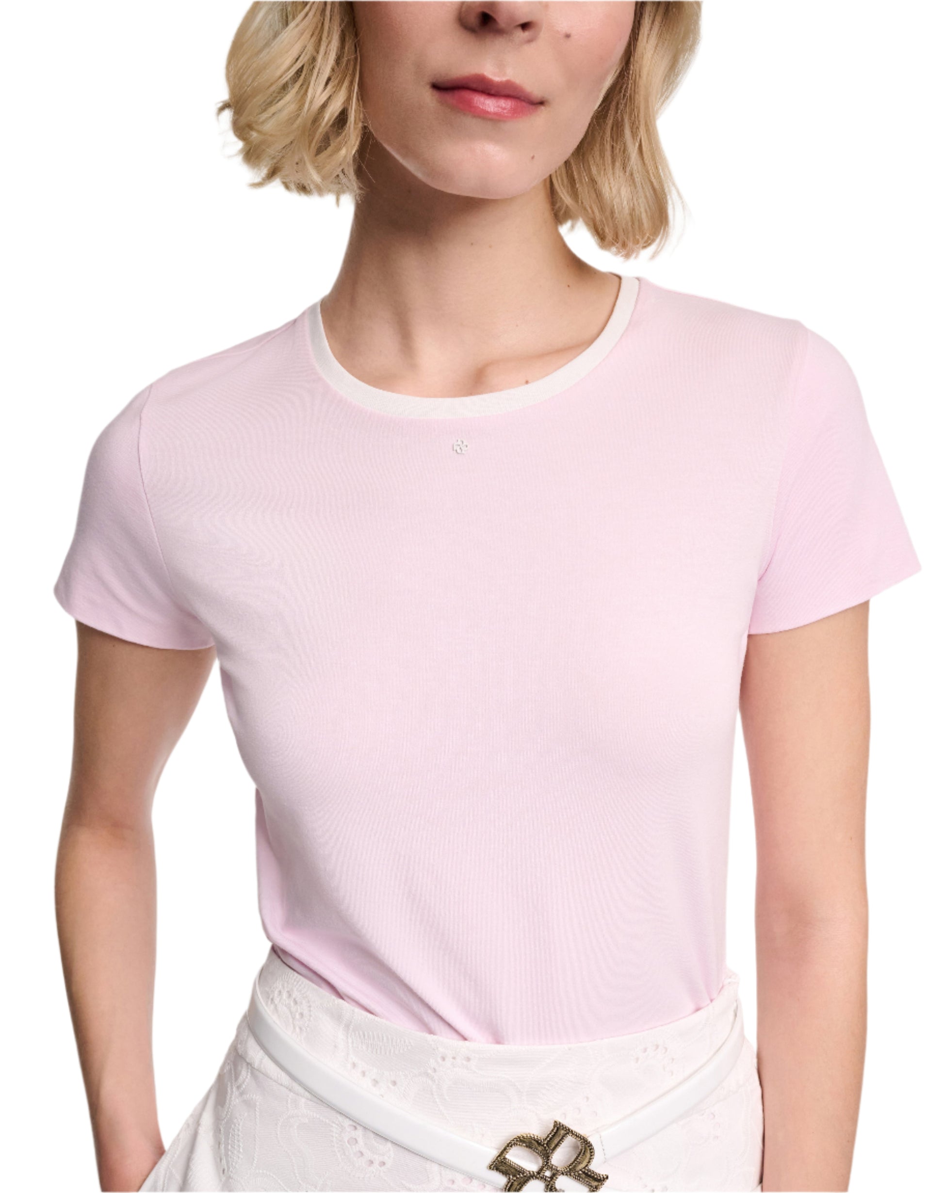 Model wearing the Dorothee Schumacher All Time Favorites Shirt in light pink, a fitted short-sleeve tee, paired with a white lace skirt featuring a decorative belt buckle; shown from shoulders to waist.