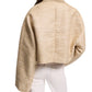 A person wears Dorothee Schumacher’s Shiny Coolness Jacket—a textured, light gold Lurex-tweed piece with a boxy silhouette and long sleeves—paired with off-white pants, shown from the back against a white background.