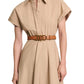 A woman wears the Dorothee Schumacher Poplin Power Dress, a beige cotton poplin shirtdress with short sleeves and a brown belt with gold rings that highlights the tailored waist.