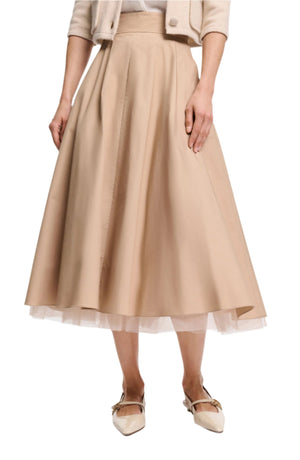A woman styles the Dorothee Schumacher Light Touch Skirt with a matching cropped jacket and white pointed-toe shoes, creating an effortlessly chic look.