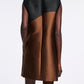 A person in the Dorothee Schumacher Soft Petal Dress, featuring a sleeveless black top and brown skirt inspired by Italian artistry, is photographed from the back against a plain background.