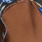 Close-up of the Soft Petal Top by Dorothee Schumacher, featuring brown cloque jacquard with blue floral embroidery and green leaf accents on a black background, highlighting exceptional Italian craftsmanship.